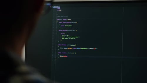 Person Coding Software on Computer Screen