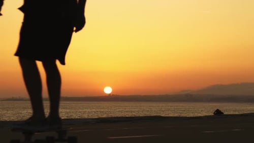 Silhouette of a Man Skateboarding at Bright Sunset