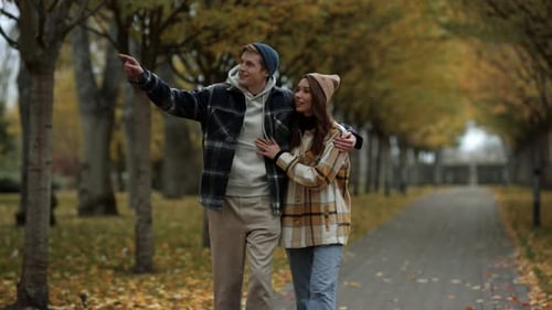 Beautiful Young Couple in Love Walking in Fall Park. Smiling Handsome Guy