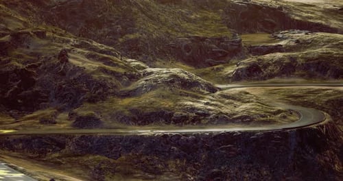 Winding Road Through Rugged Terrain Under the Soft Glow of Sunset