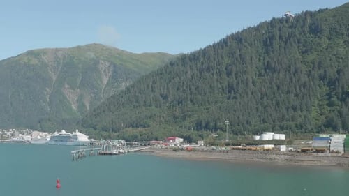 Wide dolly shot of Juneau, Alaska sea port with a cruise ship at the dock.