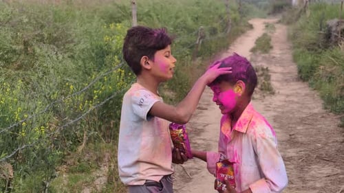 Two Boys Playing Holi with Organic Gulal in a Village Field of Madhya Pradesh