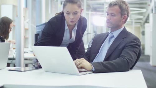 Two Office Workers Have Conversation next to Computer