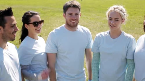 Volunteers high five in a sunny park showcasing teamwork and environmental care
