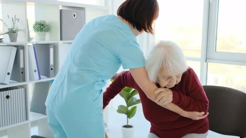 Friendly Healthcare Worker Helping Senior Woman With Cane