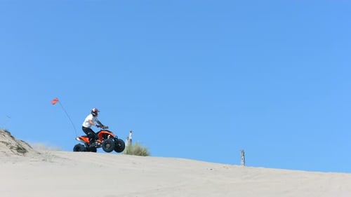 Man Jumps Quad Off Sand Dune,