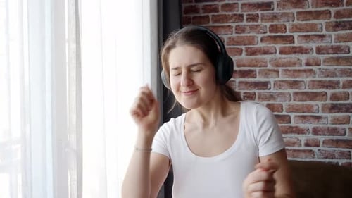 Woman with Headphones Dancing in Apartment