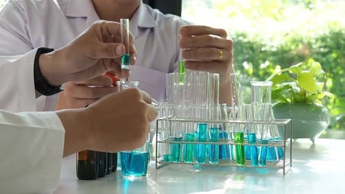 Researcher dropping the reagent or chemical liquid into test tube. Laboratory science, research