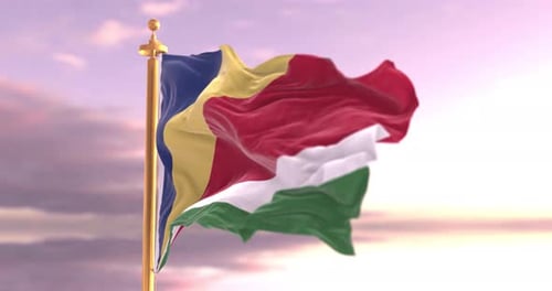 Seychelles Flag Waving on a Gold Pole at Sunset