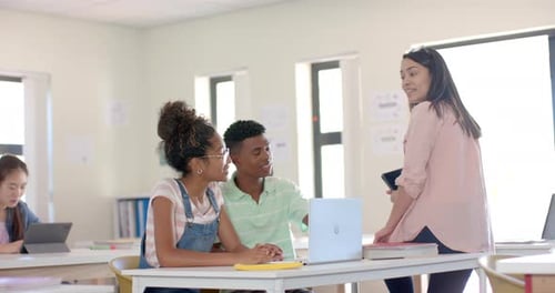 In a bright highschool classroom, a diverse group of students engages with a teacher