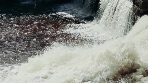 Powerful waterfall among mountain stones.