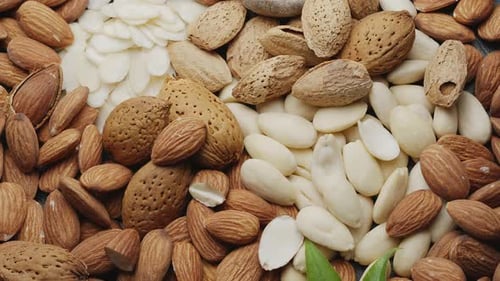 Shelled almonds, peeled almonds and almond slices close up.