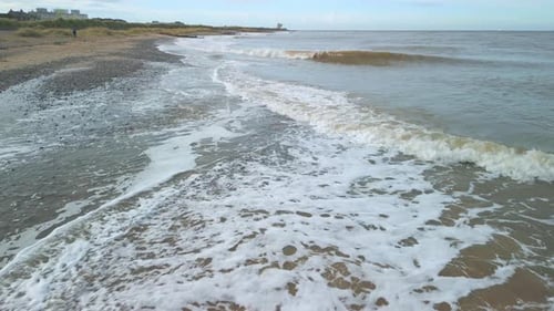 Des
calottes blanches émergeant de la mer d'Irlande trouble. Survol à basse altitude avec détecteur de métaux sur la plage. Ralenti h
