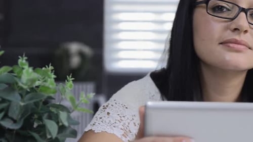 Woman Smiling and Using a Tablet Inside