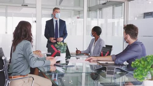 Mature Businessman Discussing Project Details with Colleagues in Modern Office with Face