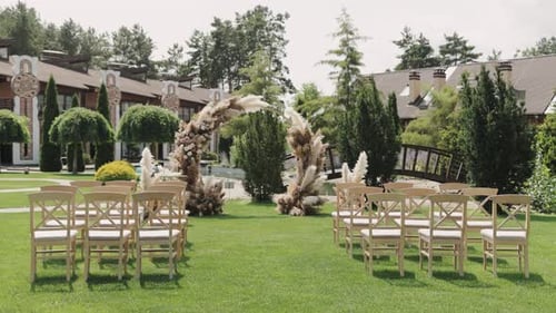 Outdoor wedding ceremony with chairs and floral arch