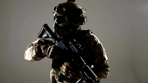 Portrait of Soldier with Rifle Communicating By Headset on Helmet During War Conflict in Studio