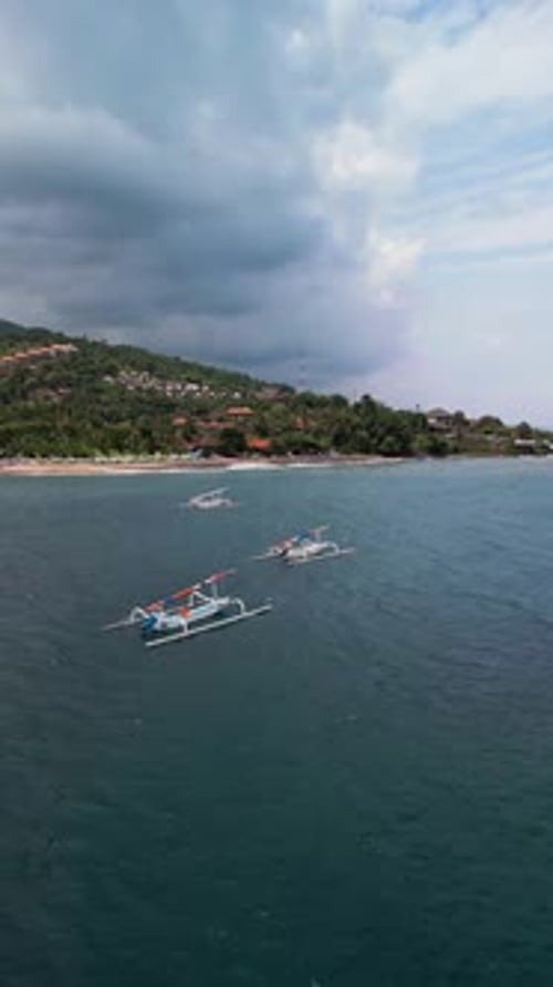 Vertical Drone Footage of Fishing Boats Anchored in Turquoise Coastal Bay Near Bali Island