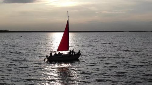 Silhouette of Sailboat With Red Sail During Sunset