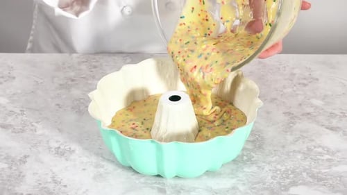 Kuchenteig in eine Bundt-Kuchenform gießen, um den Funfettti-Bundt-Kuchen zu backen