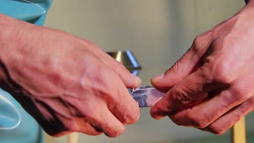 Hands Wrapping Metal Frame Around Glass Sheet