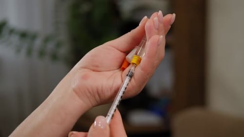 Close Up of Woman Preparing Medical Needle