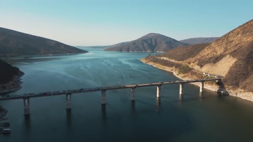 Aerial drone flying over a lake, water dam, with mountains at sunrise. Beautifull dreamy landscape v