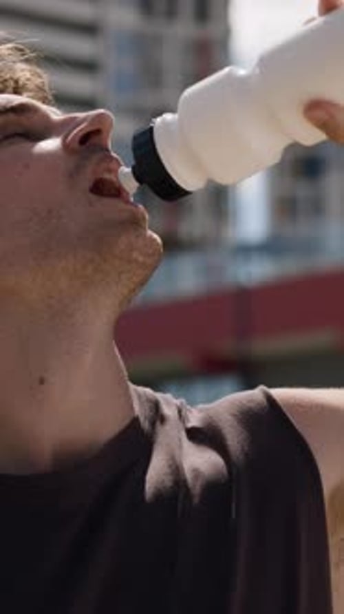 Athletic Man Drinking Water After Workout on Sunny Day