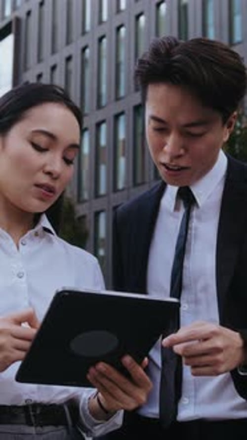 Young Asian Businesspeople Discuss Deal By Company Building