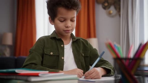 Boy Learning and Writing at a Desk