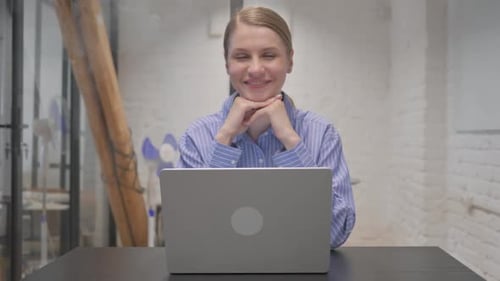 Smiling Woman Posing with Laptop at Desk