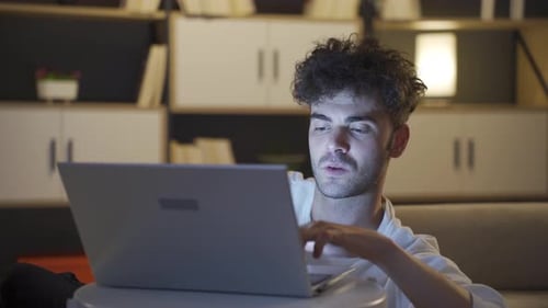 Young Adult Using Laptop at Home at Night