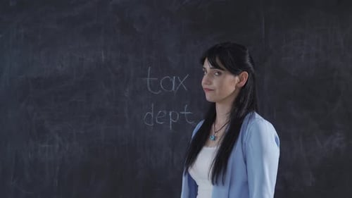 The woman who writes Tax Debt on the blackboard looks at her with a languid expression.