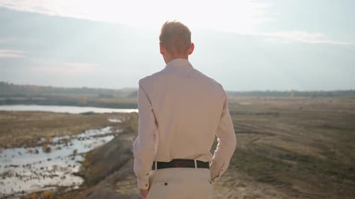 Young Man Standing on a Hill Overlooking a River Concept of Admiring Nature