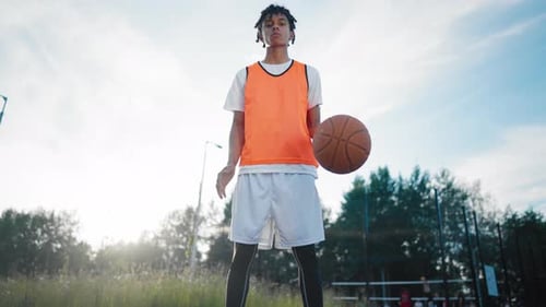 African Teen Boy Playing Basketball View on Legs and Ball on Outdoor Court Skilled Streetballer