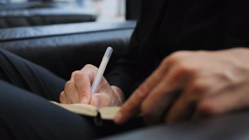 Adult Hand Writing in Notebook with a Pen