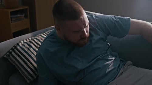 Homme portant un bracelet de cheville debout du canapé