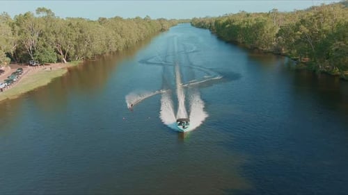 Aerial shot of Wakeboarder Towing Boat on the river. riding board behind boat.