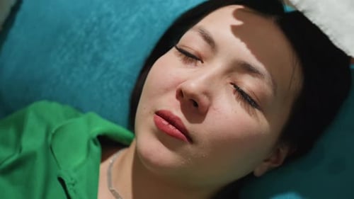 Femme recevant des soins Dame asiatique couchée paisiblement sous un doux contact de soutien, gros plan de la femme