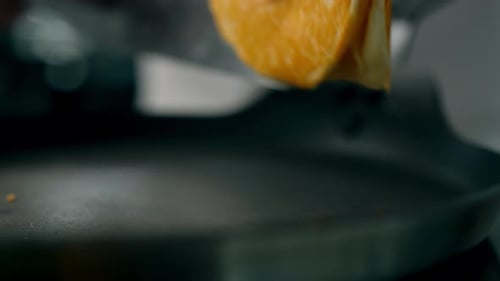 Close-up of a cook flipping a pancake in a pan