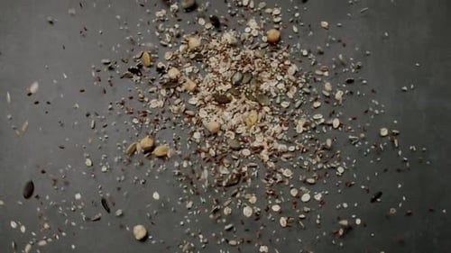 Gesundes Getreide und Nüsse, die auf dunklem Hintergrund in der Luft fliegen, for Food Concept