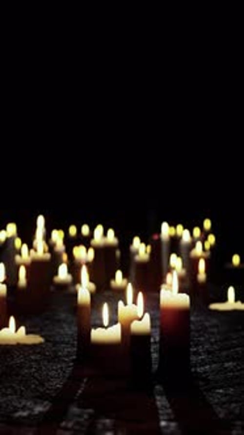 Flickering Lit Candles in a Dark and Somber Setting