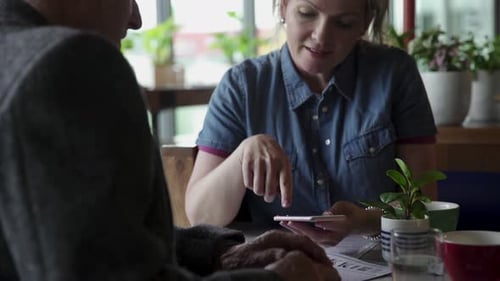Daughter and Senior Father Using Smart Phone at Cafe Table 4549 Years
