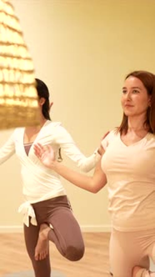 Women practicing balance poses in yoga class