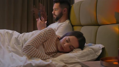 Femme caucasienne, petite amie couchée dans son lit, homme refoulé, petit ami, téléphone portable, smartphone