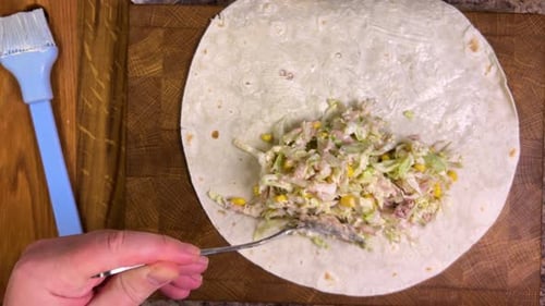 Preparing lavash with a filling of vegetables, herbs and seafood. Top view.