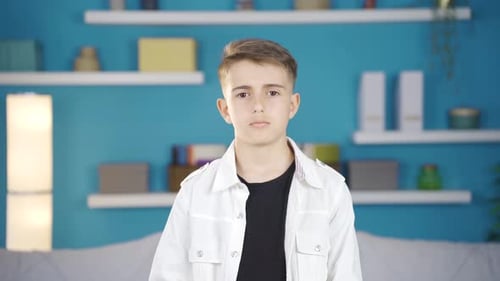 Boy looking at camera curiously thoughtful.