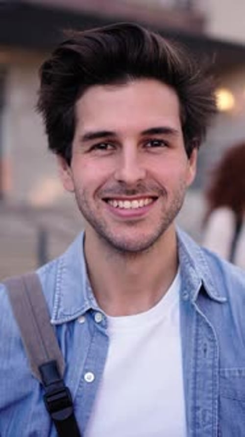 Portrait of Young Caucasian Man Student Looking Smiling at Camera in Front of a University Building