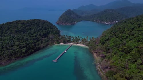 Island with pier leading to tropical beach. Gorgeous aerial view flight drone