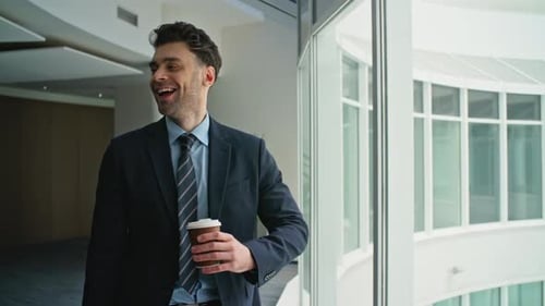 Relaxed Entrepreneur Holding Coffee Walking Near Office Hallway Windows Closeup